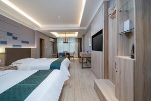 een hotelkamer met twee bedden en een televisie bij Morninginn, Zhenyu Plaza in Shaoyang County