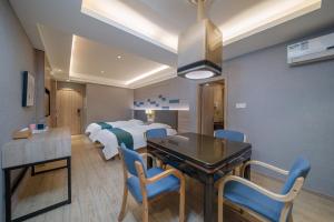 a hotel room with a dining table and a bedroom at Morninginn, Zhenyu Plaza in Shaoyang County