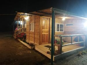 eine Holzhütte mit einer Tür und einer Veranda in der Nacht in der Unterkunft Green Bamboo Lodge in San Francisco de Borja