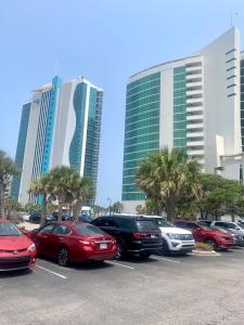 a parking lot with cars parked in front of tall buildings at Highest Ocean Front View in Myrtle Beach