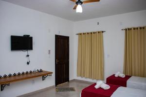 1 dormitorio con 2 camas y TV de pantalla plana en Pousada Estância Tertúlia, en São Tiago