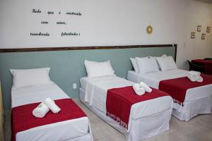 una camera con tre letti con asciugamani di Pousada Estância Tertúlia a São Tiago