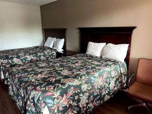 a hotel room with two beds and a chair at Budget Plaza Motel in Brooklyn Park