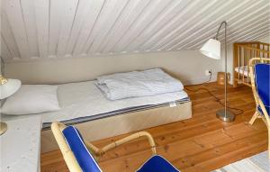 Ce lit se trouve dans un dortoir doté de chaises et d'une lampe. dans l'établissement Beautiful Home In Valdemarsvik With Sauna, à Valdemarsvik