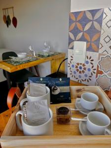 a tray with cups and saucers on a table at Alto da Villa in Ouro Preto