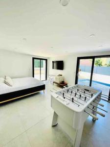 Großes weißes Zimmer mit einem Bett und einem großen Tisch. in der Unterkunft Villa Neuve Piscine Privée La Ciotat in La Ciotat + 13 Fotos