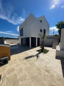 ein weißes Gebäude mit einer Palme davor in der Unterkunft Villa Neuve Piscine Privée La Ciotat in La Ciotat