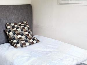 a bed with a checkered pillow on top of it at Holiday home ENVIKEN in Svärdsjö