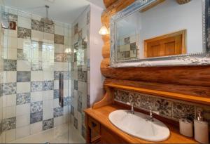 bagno con lavandino, doccia e specchio di Fairytale Log Cabin - Homewood Forest Retreat ad Alexandra