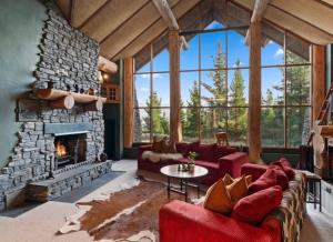 uma sala de estar com lareira de pedra e sofás vermelhos em Fairytale Log Cabin - Homewood Forest Retreat em Alexandra