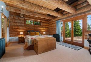 a log cabin bedroom with a bed and windows at Fairytale Log Cabin - Homewood Forest Retreat in Alexandra