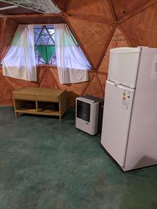 einen Kühlschrank und eine Mikrowelle in einem Zelt in der Unterkunft Cabaña Domo Delta in Los Cocos