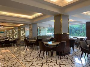 a restaurant with tables and chairs in a room at Jomtien Holiday Pattaya in Jomtien Beach