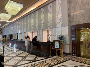 a man and a woman standing at a counter in a lobby at Jomtien Holiday Pattaya in Jomtien Beach