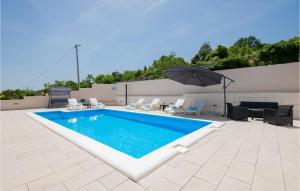 einen Pool mit Sonnenschirm auf einer Terrasse in der Unterkunft 3 Bedroom Nice Home In Lokvicici in Lokvičič