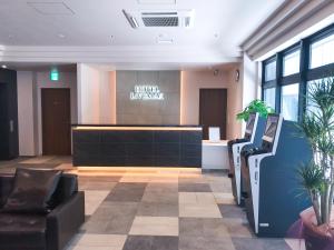 札幌的住宿－HOTEL LiVEMAX PREMIUM Sapporo Odorikoen，一间设有前台和椅子的等候室