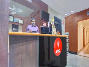 a man standing at the counter of a office at Collection O Alekhya Residency in Hyderabad