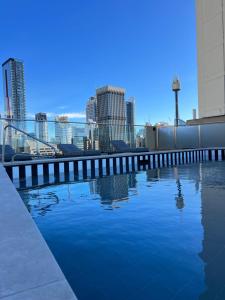 a swimming pool with a city skyline in the background at Paxsafe Sydney Hyde Park Private Apartments in Sydney