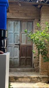 eine Holztür eines Hauses mit einer Pflanze davor in der Unterkunft Casa Cristal in Chiapa de Corzo