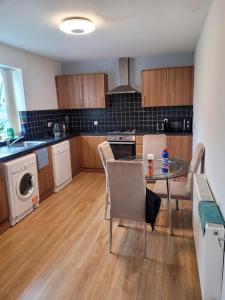 a kitchen with a table and chairs in a room at No 1 Decent Homes- Quiet double bedroom in Dukinfield