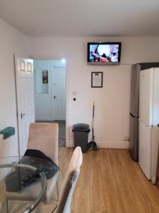 sala de estar con mesa de cristal y TV en la pared en No 1 Decent Homes- Quiet double bedroom, en Dukinfield
