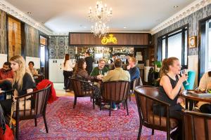 un grupo de personas sentadas en mesas en un restaurante en Prince's Gate Hotel, en Rotorua