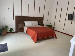 a bedroom with a bed with a red blanket at Casa Cristal in Chiapa de Corzo