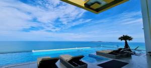 a swimming pool with a view of the ocean at Seaview Beachfront Skypool Rooftop Copacabana Jomtien Condo in Jomtien Beach