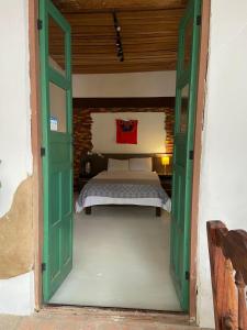 ein Schlafzimmer mit einem Bett und einer offenen Tür in der Unterkunft Casa Cristal in Chiapa de Corzo