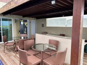 a patio with a table and chairs and a bar at Flat Beira Mar de Intermares in Cabedelo