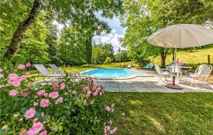 Caylusにある4 Bedroom Amazing Home In Caylusのテーブルと傘とピンクの花が飾られたプールを提供しています。