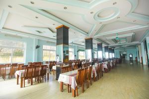 a dining room with tables and chairs in a restaurant at Thành Thư Vân Đồn Hotel - by Bay Luxury in Quang Ninh