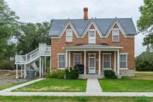 a red brick house with a white porch and stairs at Panguich Red Brick Homes upper Home in Panguitch