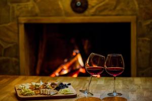two glasses of wine and a plate of food on a table with a fireplace at Park Mandalin Hotel - Adult only in Ağva