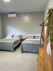 pokój z 2 łóżkami i rośliną w obiekcie Morada da Ilha Pousada w mieście Soure