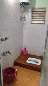 ein Bad mit WC in der Ecke eines Zimmers in der Unterkunft Acharyaa Homestay in Tiruchchirāppalli