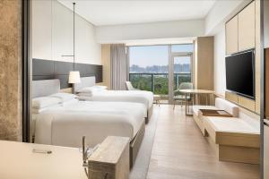 a hotel room with two beds and a television at Yantai Marriott Hotel in Yantai