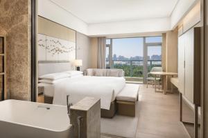 a hotel room with a bed and a bath tub at Yantai Marriott Hotel in Yantai