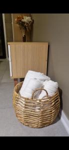 Una cesta de toallas está sentada junto a una pared. en Studio ideal viaje en pareja o trabajo en San Miguel de Tucumán
