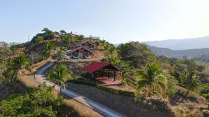 a house on the side of a hill with a road at Surf Synergy All-Inclusive Surf Retreat in Jacó