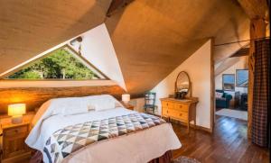 a bedroom with a bed and a large window at Magical Loft - Homewood Forest Retreat in Alexandra