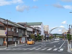 a yellow van driving down a city street at ひろの家 in Fukuchiyama