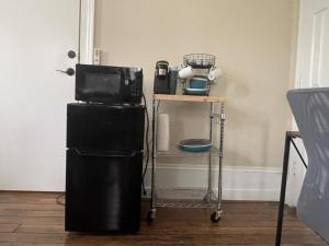 einen schwarzen Kühlschrank neben einem Tisch mit einer Mikrowelle in der Unterkunft Suite2-1King Bed1Bath-1BlockFromMercerHospitals in Macon