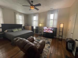 a bedroom with a bed and a couch and a television at Suite2-1King Bed1Bath-1BlockFromMercerHospitals in Macon