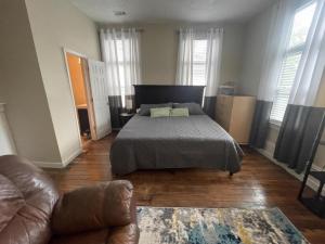 a bedroom with a bed and a couch at Suite2-1King Bed1Bath-1BlockFromMercerHospitals in Macon