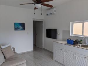 a living room with a ceiling fan and a couch at Hermoso departamento en Cancún YaxBahia 3 in Cancún