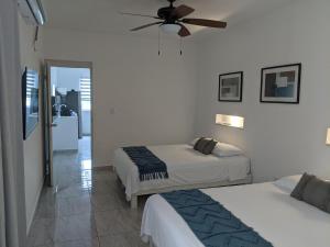 a bedroom with two beds and a ceiling fan at Hermoso departamento en Cancún YaxBahia 3 in Cancún