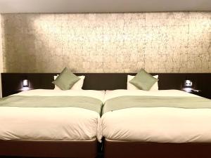 two beds sitting next to each other in a bedroom at Homm Stay Nagi Sanjo Kyoto By Banyan Group in Kyoto