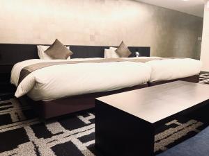 a large bed with white sheets and pillows in a bedroom at Homm Stay Nagi Sanjo Kyoto By Banyan Group in Kyoto