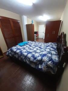 1 dormitorio con 1 cama con manta azul y blanca en Valentino Apart II en Jesús María